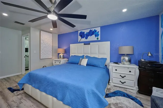 a spacious bedroom with a bed and a flat screen tv