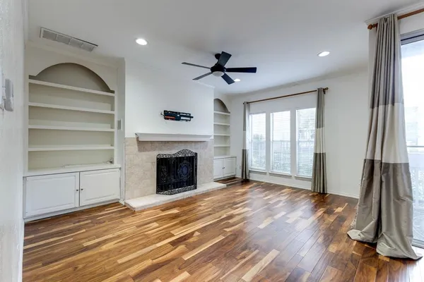 a view of a livingroom with a fireplace a ceiling fan and entryway