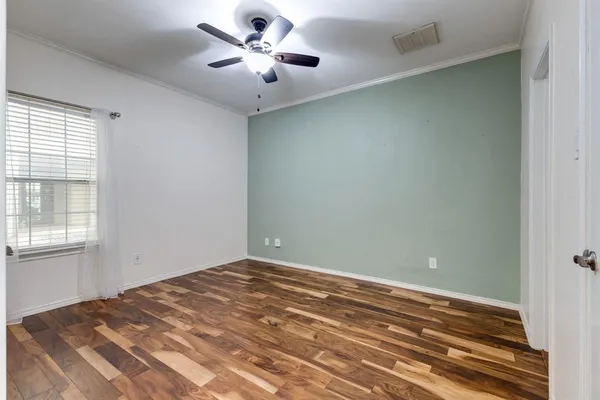 a view of empty room with wooden floor