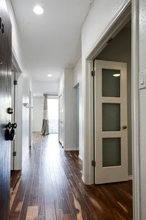 a view of a hallway with wooden floor and closet