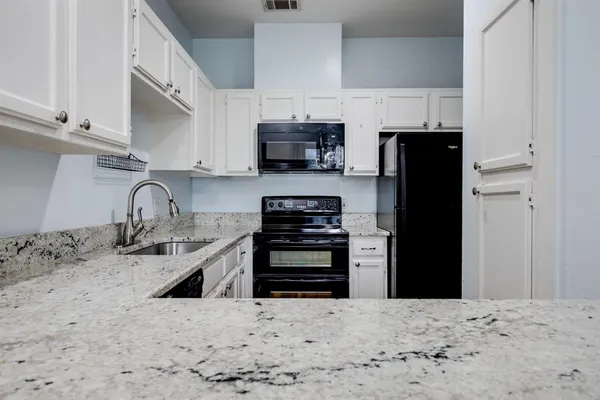 a kitchen with stainless steel appliances kitchen island a refrigerator sink and cabinets