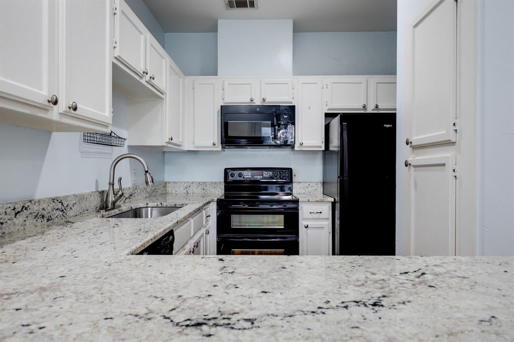 5310 Keller Springs Road, Unit 413 Dallas, TX 75248 - Photo 7 of 20 a kitchen with stainless steel appliances kitchen island a refrigerator sink and cabinets
