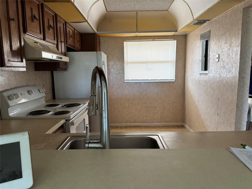 3650 Environ Boulevard, Unit 308 Lauderhill, FL 33319 - Photo 11 of 14 a kitchen with stainless steel appliances granite countertop a sink a stove and a refrigerator