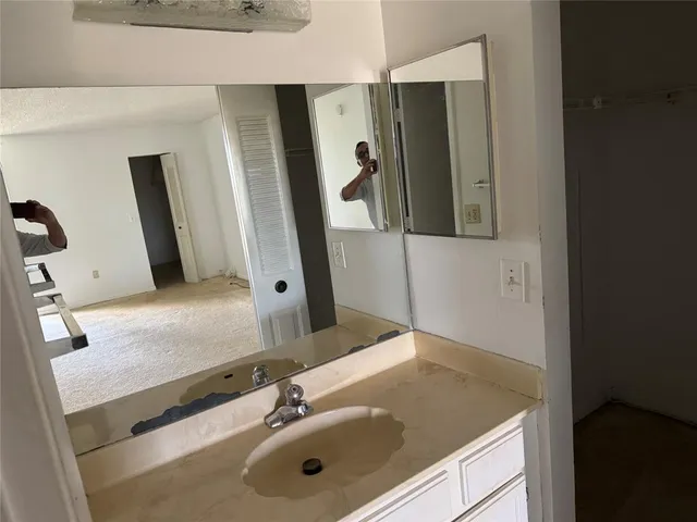 a bathroom with a sink vanity and mirror