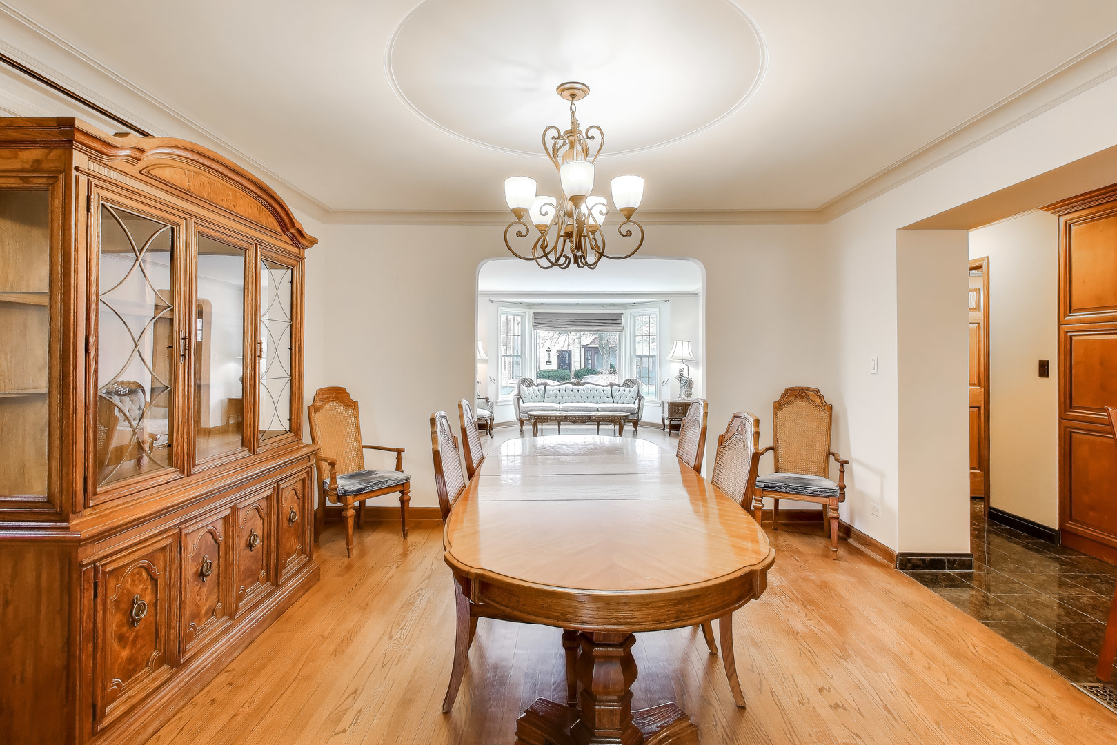 6230 North Troy Street Chicago, IL 60659 - Photo 7 of 38 a dining room with wooden floor a chandelier a wooden table and chairs