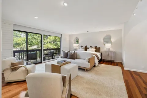 a bedroom with furniture and large windows