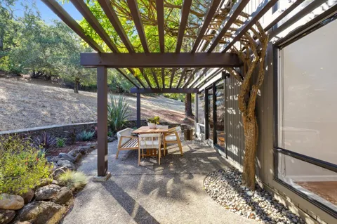 a view of a house with backyard outdoor seating and wooden fence