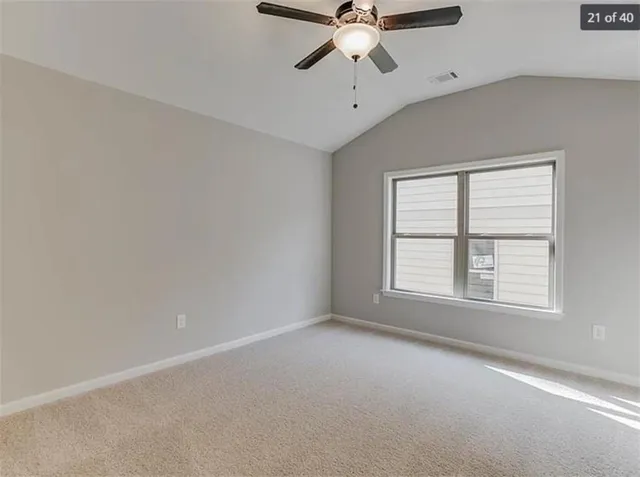 an empty room with a window and a fan