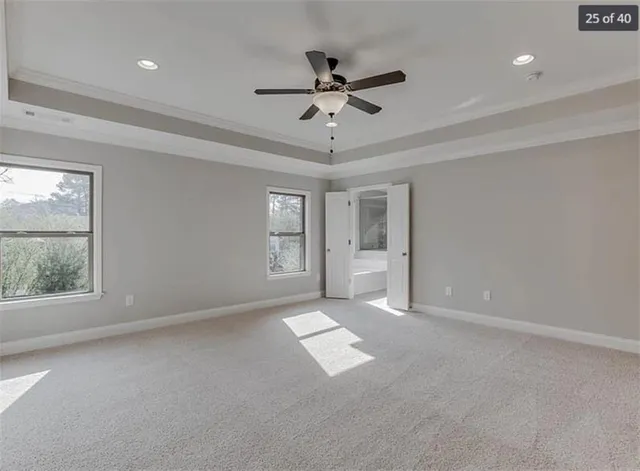 an empty room with windows and ceiling fan