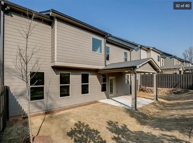 a view of a white house with a large window and wooden fence