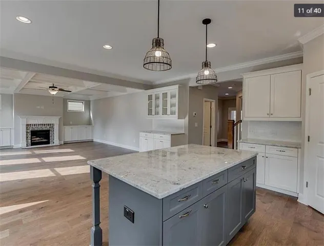 a kitchen with a stove center island a sink dishwasher a dining table and chairs with wooden floor