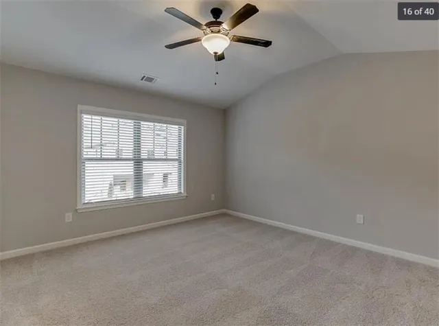 an empty room with a window and a fan