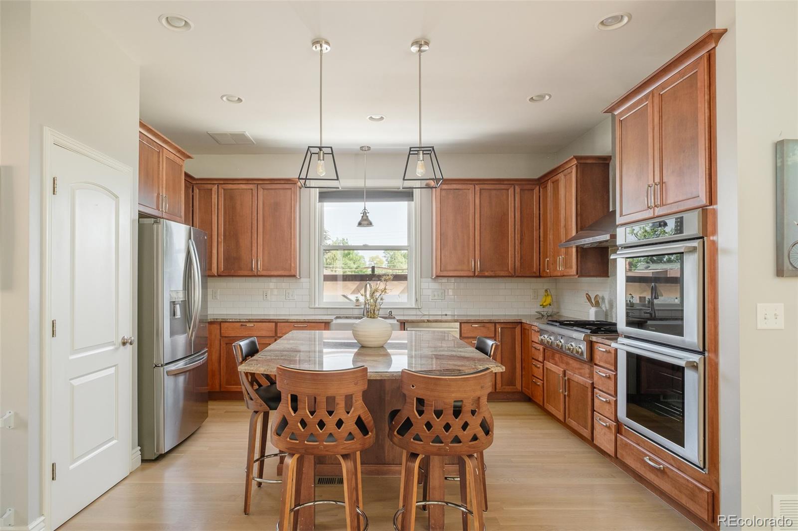 3234 Stuart Street Denver, CO 80212 - Photo 11 of 41 a kitchen with stainless steel appliances granite countertop a refrigerator a sink dishwasher a stove a kitchen island with a dining table and chairs