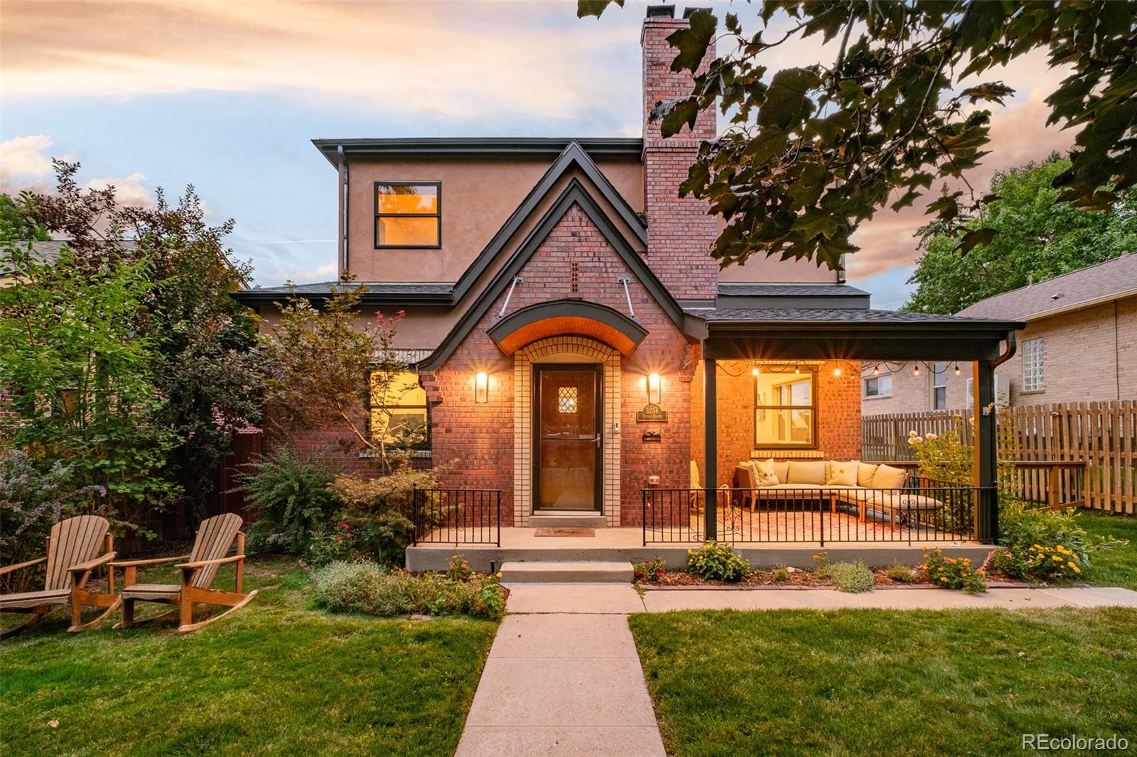 3234 Stuart Street Denver, CO 80212 - Photo 33 of 41 a view of a brick house with a large windows and a yard with plants and large trees