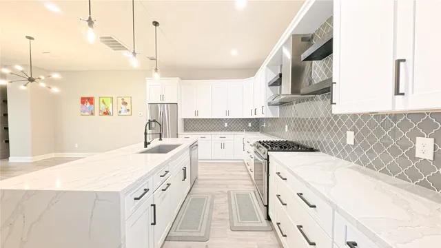 a large white kitchen with sink and dishwasher