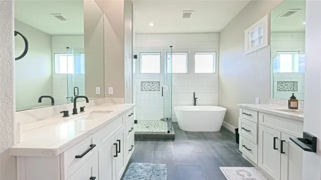 a bathroom with a double vanity sink a toilet and shower