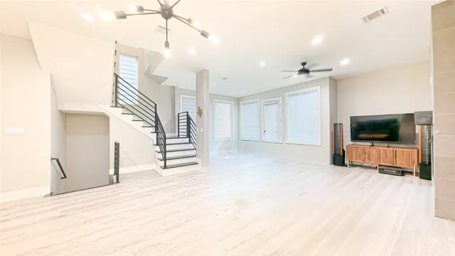 a view of a livingroom with wooden floor and a ceiling fan