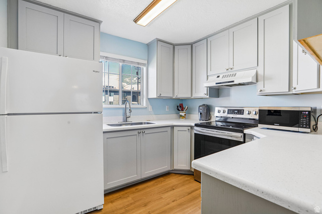 888 600 West, Unit 40 Provo, UT 84604 - Photo 2 of 19 Kitchen featuring light gray cabinetry, white countertops, stainless steel appliances, wood-finish flooring, and a window above the sink