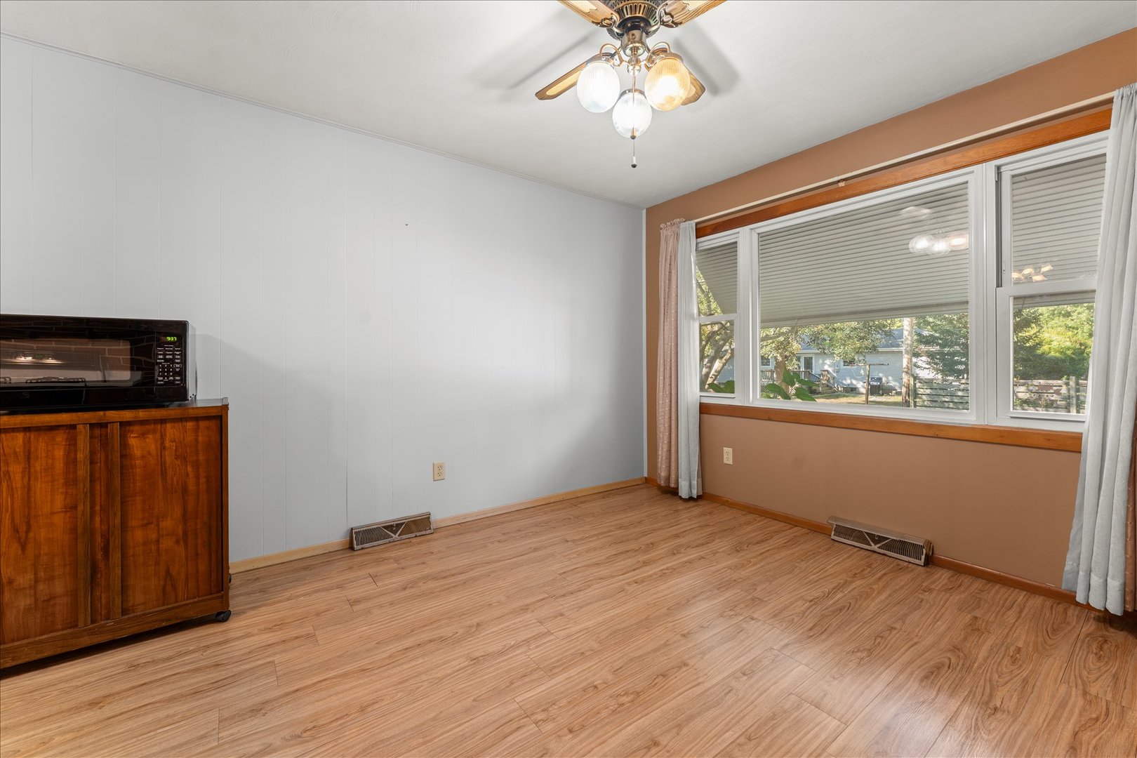 708 Jackson Street Monticello, IL 61856 - Photo 11 of 28 an empty room with wooden floor fan and windows