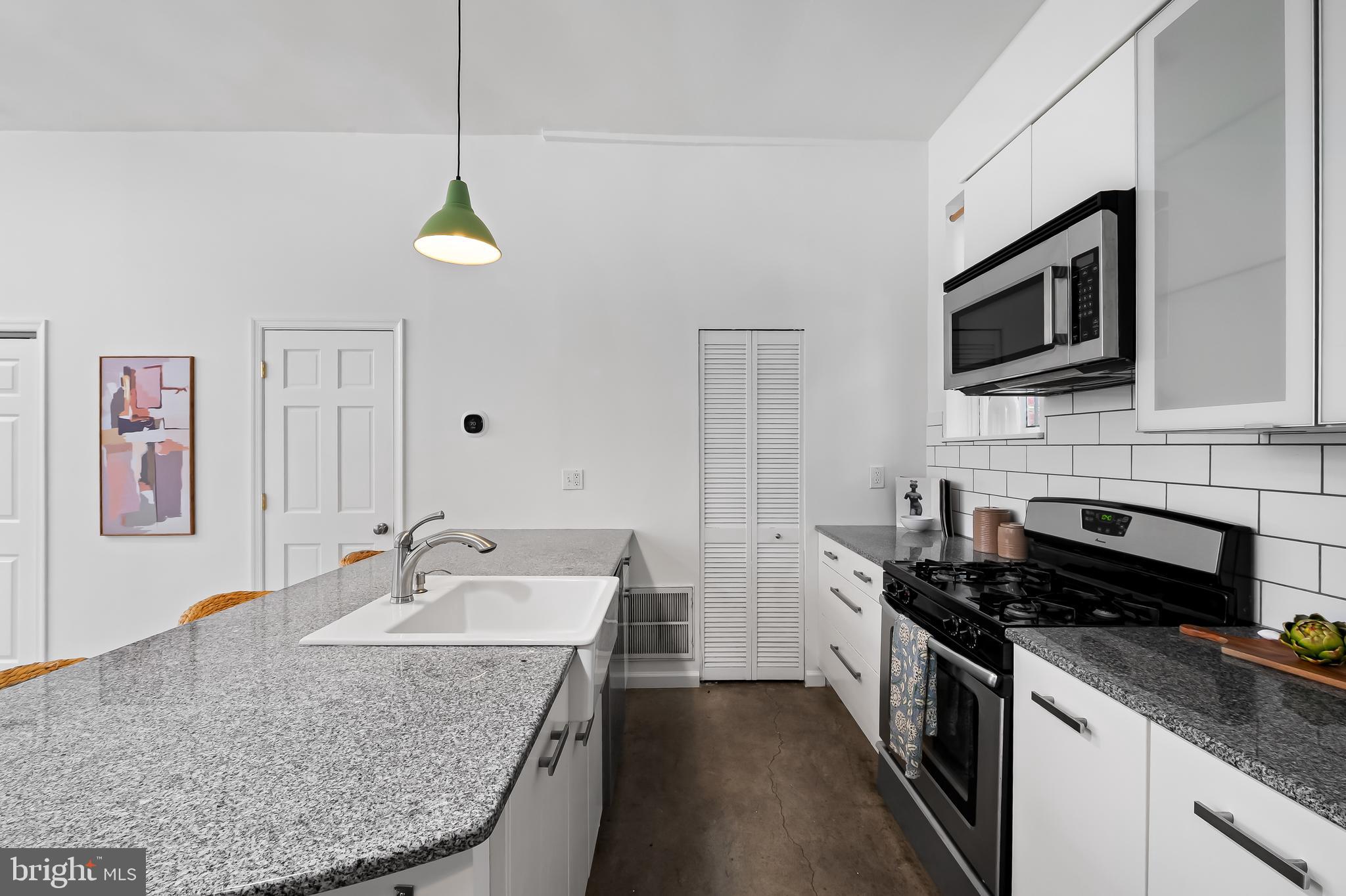 307 Mosher Street Baltimore, MD 21217 - Photo 13 of 30 a kitchen with stainless steel appliances granite countertop a sink stove and microwave