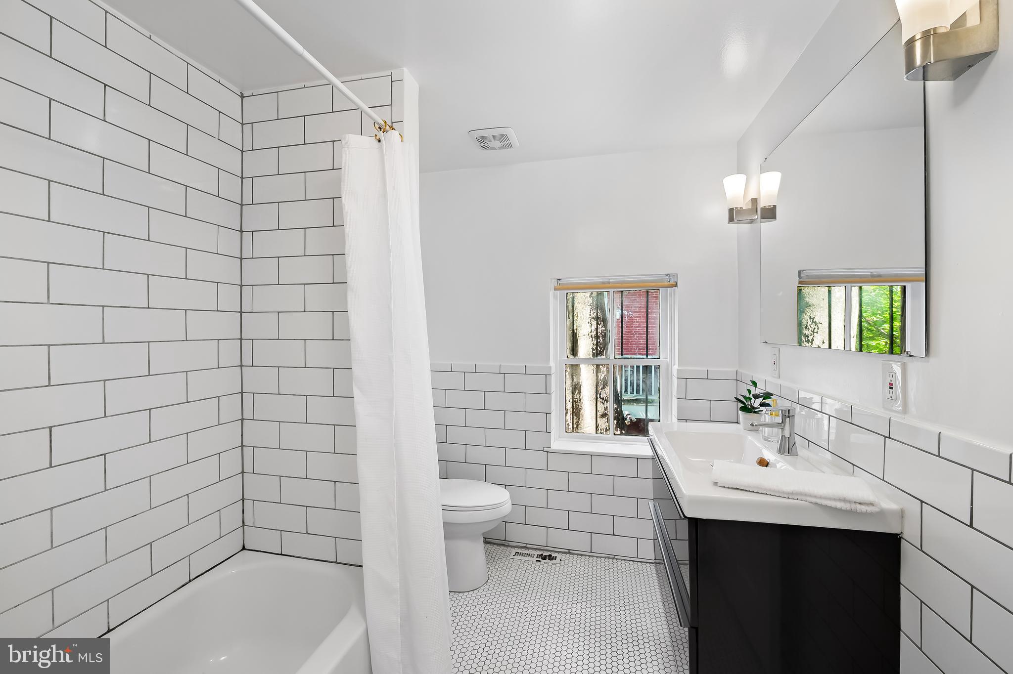 307 Mosher Street Baltimore, MD 21217 - Photo 29 of 30 a bathroom with a sink a toilet and shower