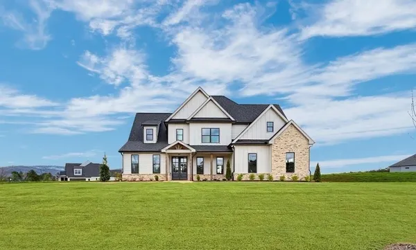 a view of a house with a big yard and large trees