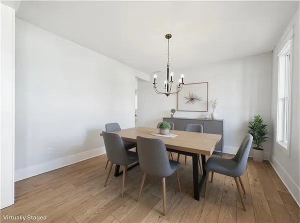 an empty room with wooden floor fireplace and windows