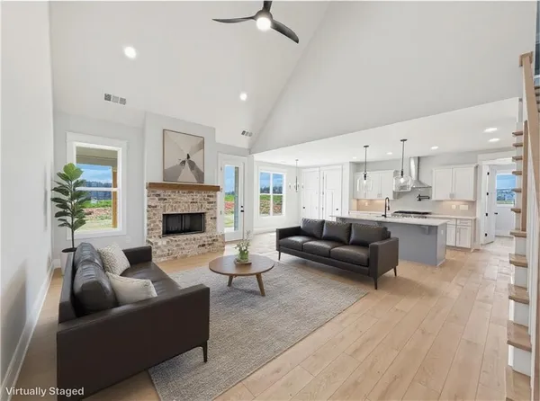 a view of an empty room with wooden floor fireplace and a window