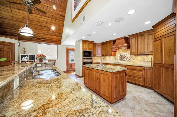a living room with stainless steel appliances granite countertop a sink and a refrigerator