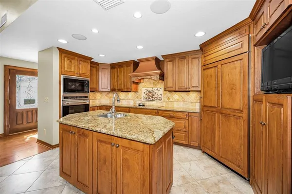 a kitchen with stainless steel appliances granite countertop a sink and a large window