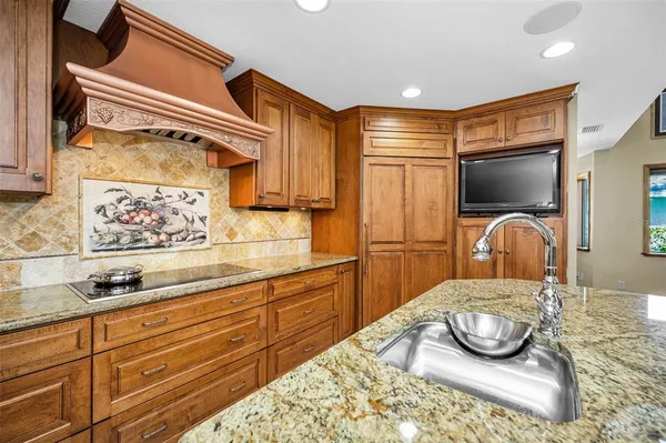a dining room with stainless steel appliances granite countertop a stove and chairs with wooden floor