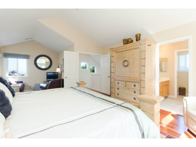 513 Monterey Road, Unit B Pacifica, CA 94044 - Photo 18 of 23 a bedroom with a bed and a chandelier