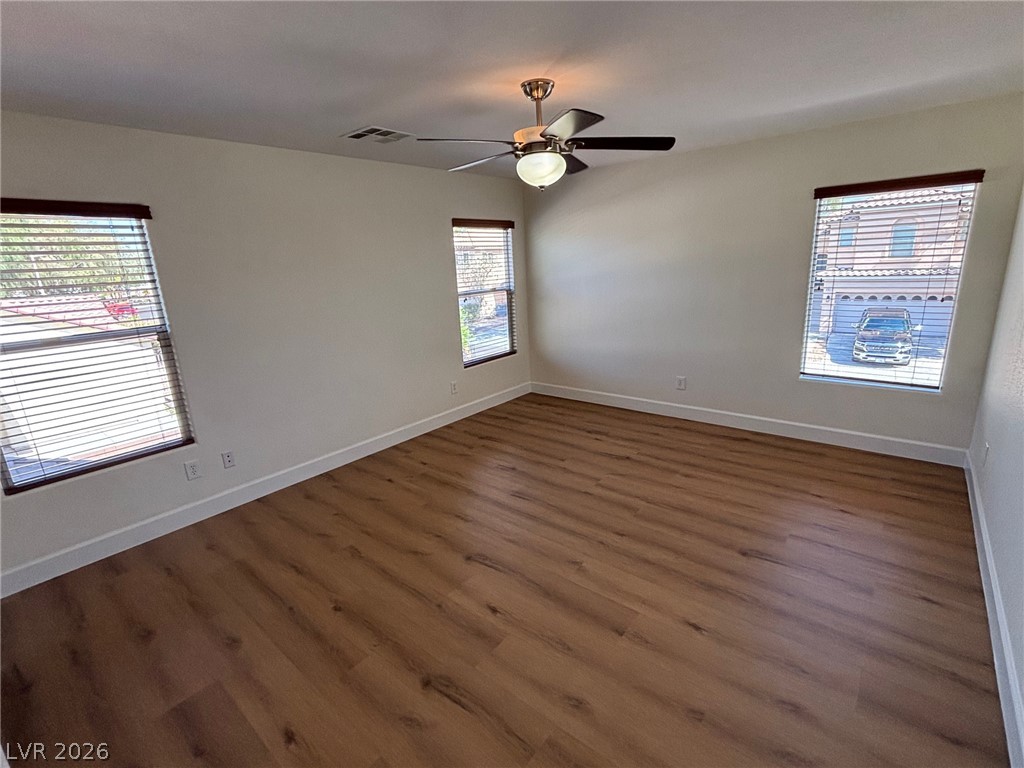 4900 Naff Ridge Drive Las Vegas, NV 89131 - Photo 11 of 21 A quiet bedroom featuring rich hardwood flooring and a stylish ceiling fan for comfort.