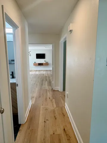 a view of a hallway with wooden floor and staircase