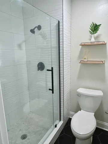 a bathroom with a toilet and a shower