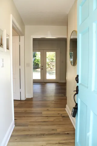 a view of a hallway with wooden floor and glass door