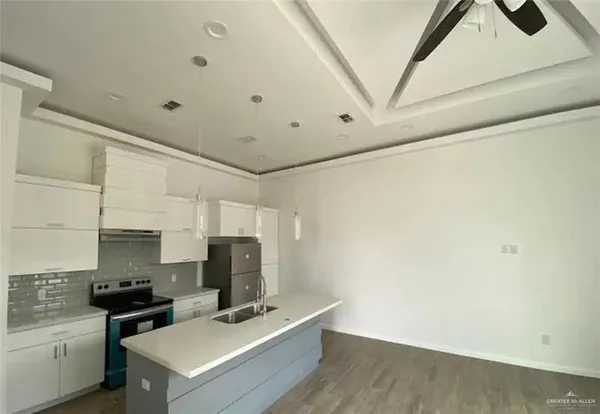 a kitchen with a stove cabinets and wooden floor