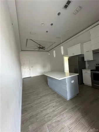 a view of kitchen with refrigerator and microwave