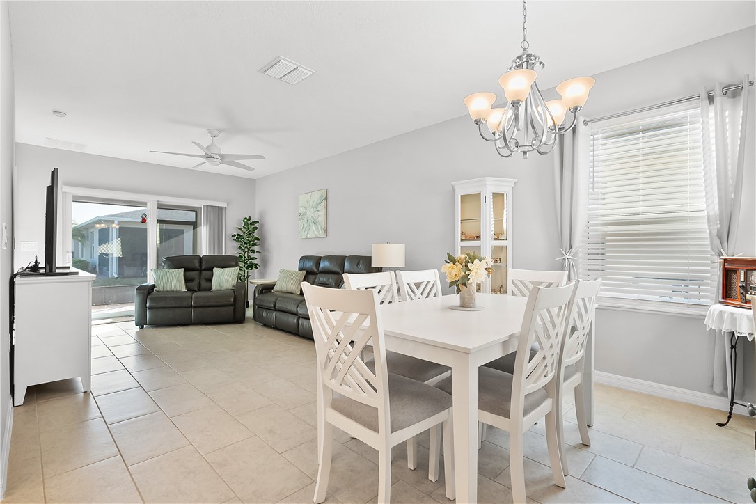 6187 Red Maple Manor Vero Beach, FL 32966 - Photo 10 of 31 a view of a dining room with furniture and a chandelier