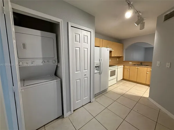 a kitchen with white cabinets and refrigerator