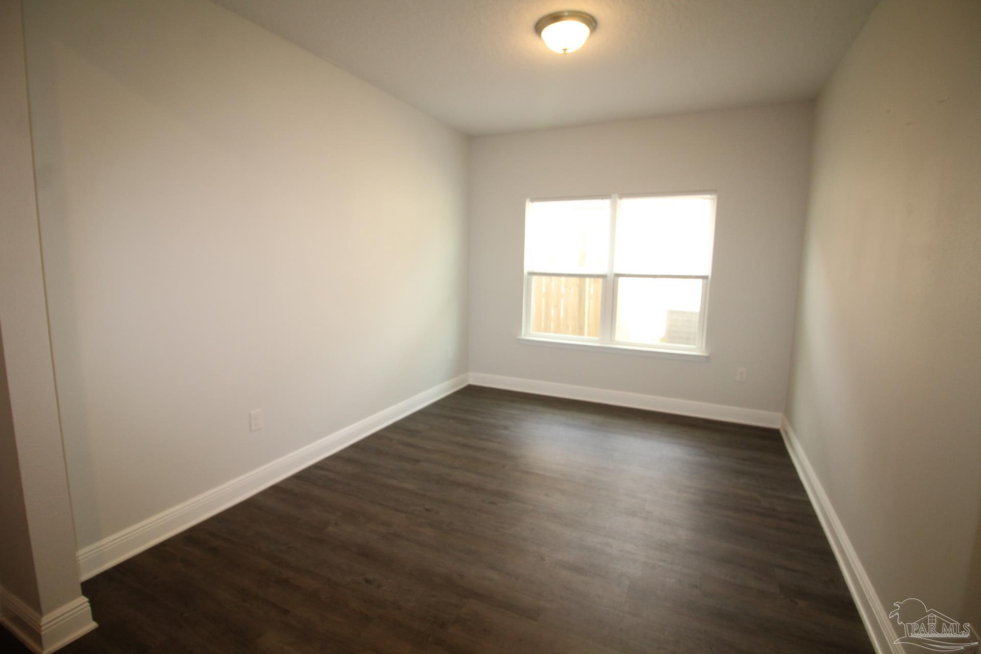 8006 Burnside Loop Pensacola, FL 32526 - Photo 6 of 22 an empty room with wooden floor and windows