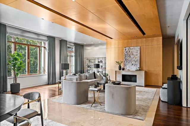 a living room with furniture a fireplace and a floor to ceiling window