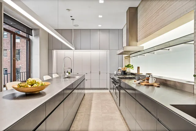 a kitchen with stainless steel appliances granite countertop a sink counter space and living room area