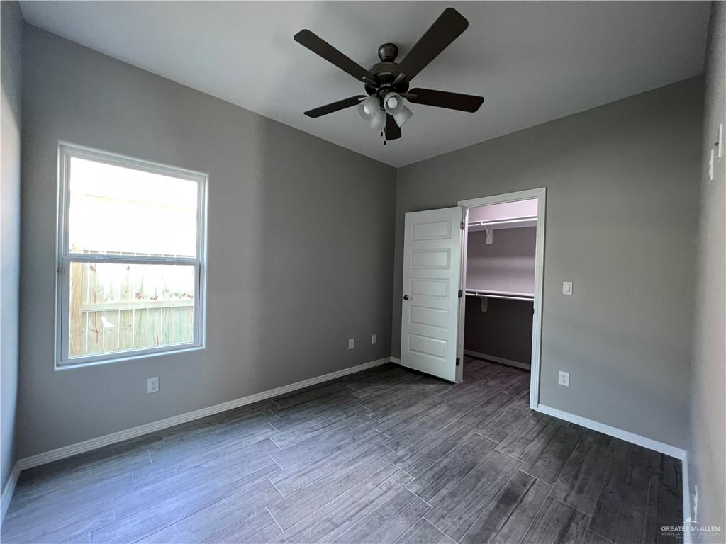 1812 Red Bud Drive, Unit 1 Weslaco, TX 78596 - Photo 11 of 25 an empty room with wooden floor chandelier fan and windows