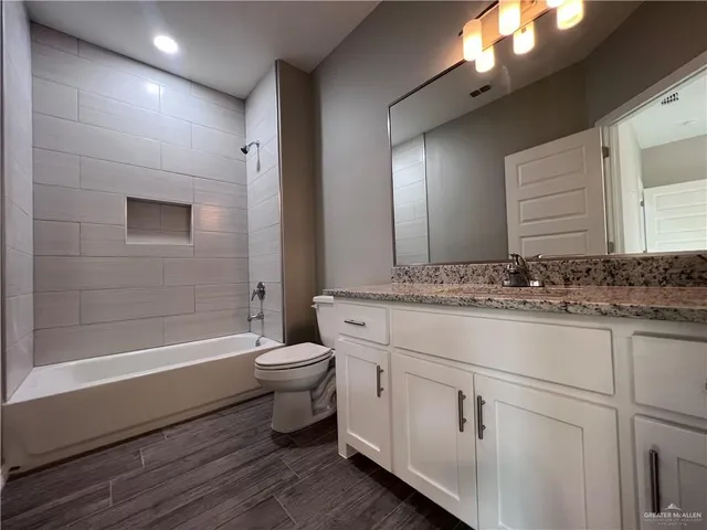 a bathroom with a sink a toilet a mirror and bathtub