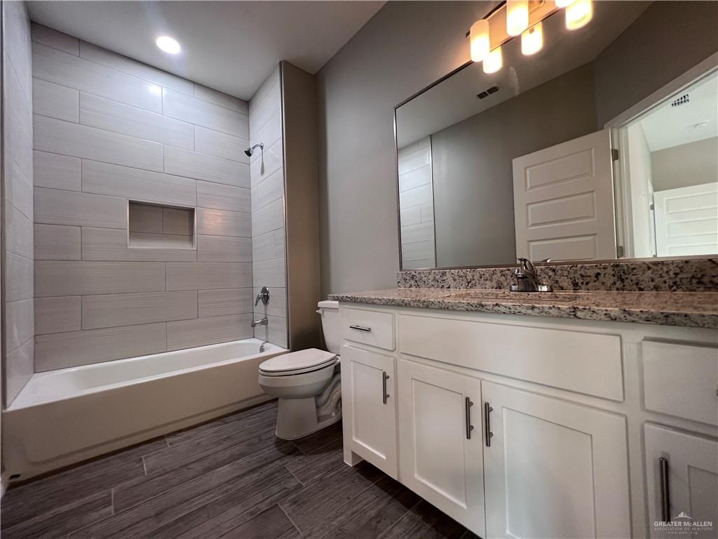 1812 Red Bud Drive, Unit 1 Weslaco, TX 78596 - Photo 19 of 25 a bathroom with a sink a toilet a mirror and bathtub