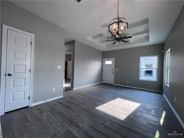 a view of a room with wooden floor and chandelier