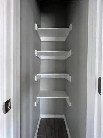 a view of walk in closet with empty racks