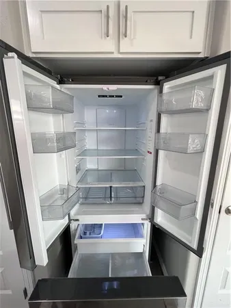 a refrigerator sitting in a kitchen next to a window