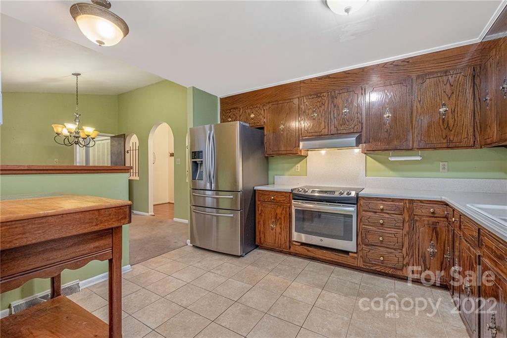 1446 McIlroy Road, Unit 8 Charlotte, NC 28212 - Photo 14 of 30 a kitchen with stainless steel appliances granite countertop a stove a refrigerator and a wooden cabinets